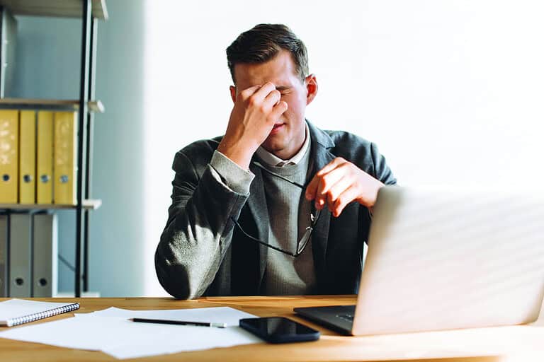 Modern man with glasses, office worker tired at work