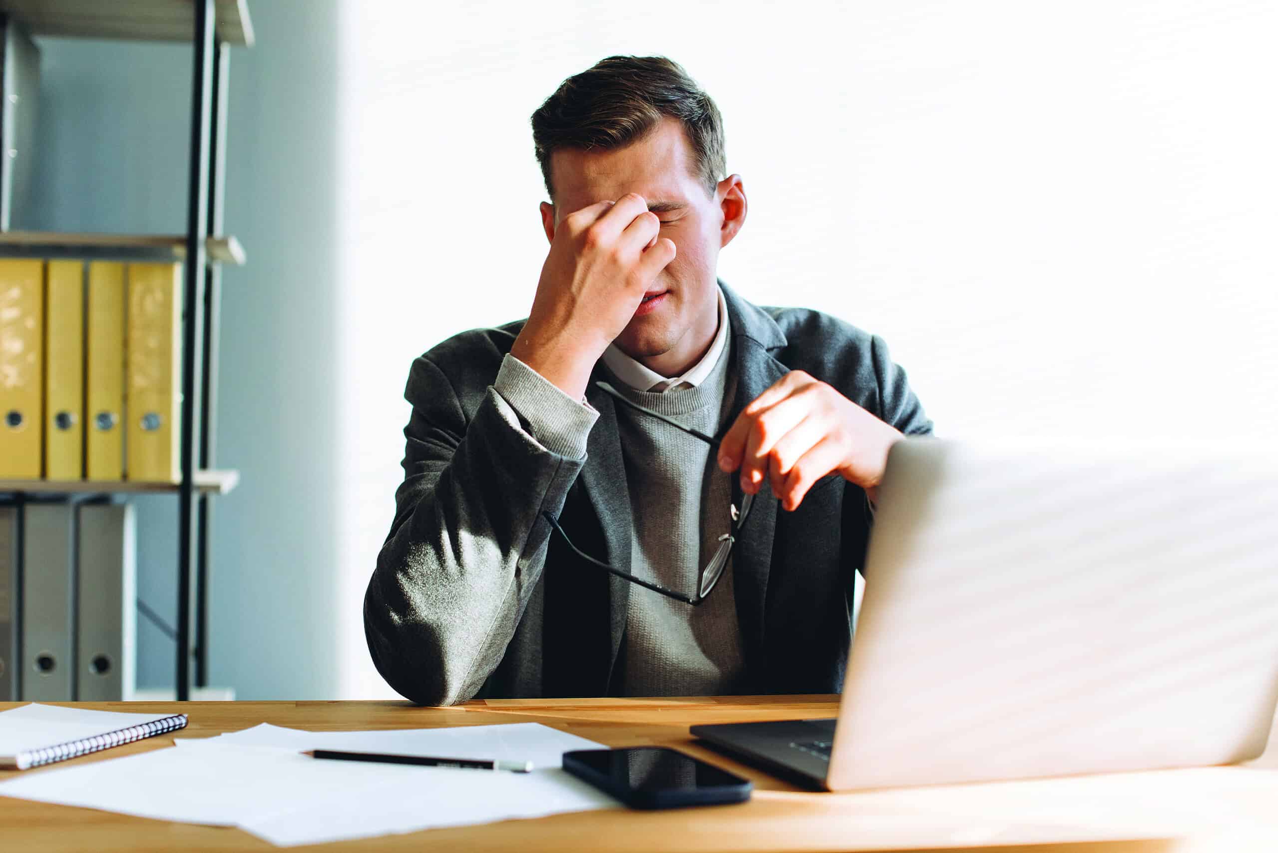 Modern man with glasses, office worker tired at work