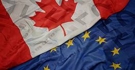 waving colorful flag of european union and flag of canada on a euro money banknotes background. finance concept. macro